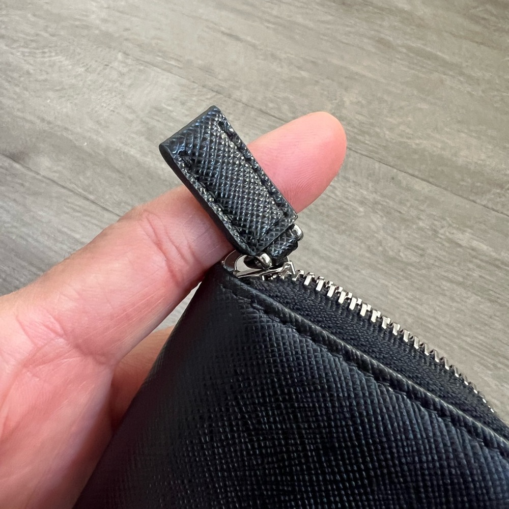 snap-hook and ring
Zipper closure
Enameled metal triangle logo
Two card slots - Picture 5 of 11
